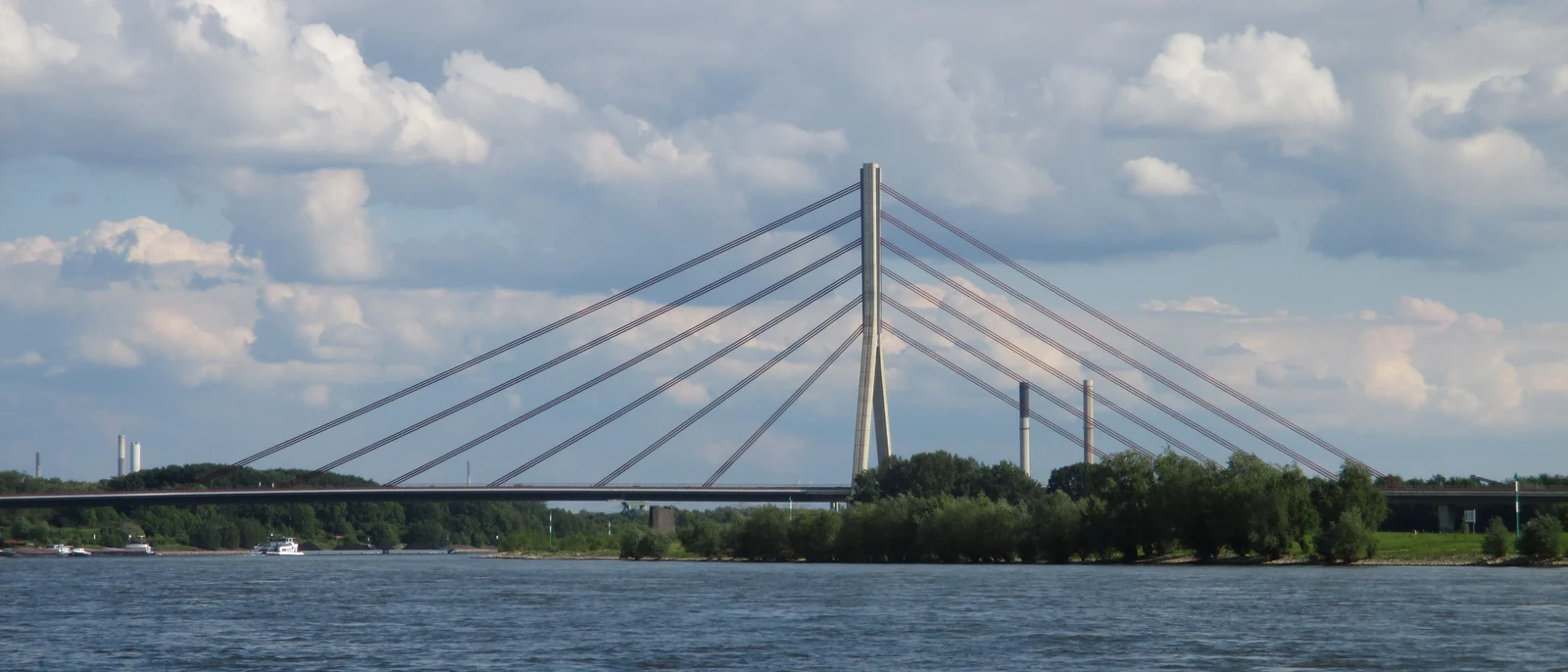 Niederrheinbrücke über dem Rhein bei Wesel, dahinter die niederrheinische Industrielandschaft